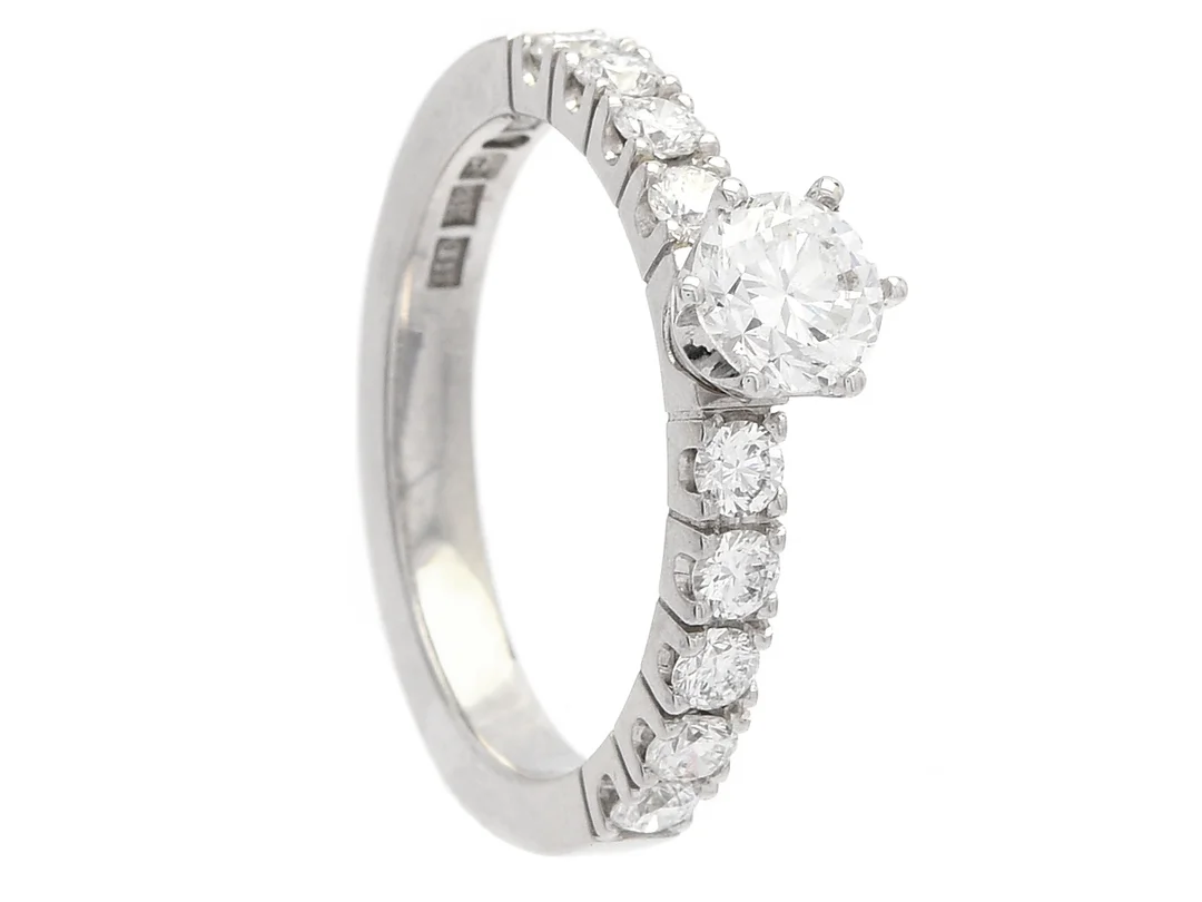 RING, 18K vitguld, briljantslipad diamant ca 0,60 ct, ca R(E)/VS2, 9 briljantslipade diamanter ca 0,54 ctv, ca TW-W/VVS-VS, stl 17,75 mm, vikt 5,6 g. — Smycken/Ring — Kaplans