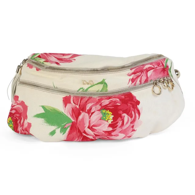 A belt bag of white printed canvas, adorned with a floral motif and gold-tone hardware, featuring white leather charms, an adjustable shoulder strap, a front zip pocket, a central zip compartment with an interior zip pocket, and grey textile lining. H. 28 × W. 72 × D. 20 cm. 2011.