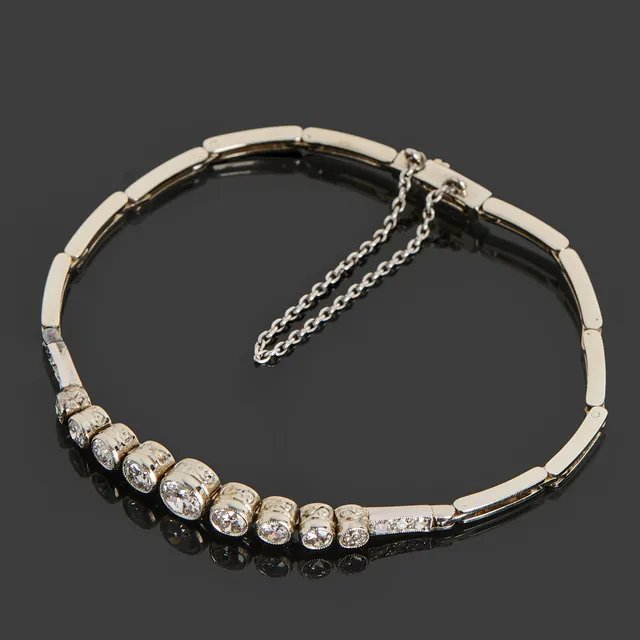 ARMBAND, Art Deco, 18k vitguld, halvledad länk dekorerat med 15 st briljantslipade diamanter totalt ca 1.20ct, millegriffdekor, 1932, Guldvaruaktiebolaget G. Dahlgren & Co Ab, Malmö.