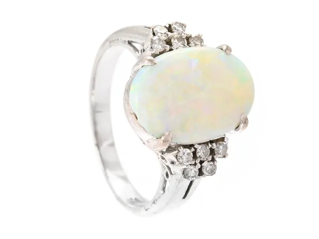 RING, 18K vitguld, cabochonslipad opal, 10 åttkantslipade diamanter ca 0,13 ctv, stl 16,75 mm, vikt 4,3 g.