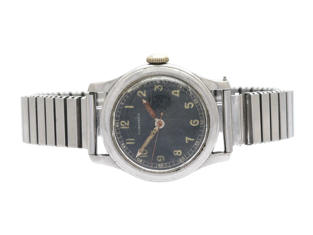 LONGINES, herrur, 33,5 mm, Cal 12.68N, Serie nr. 6629934, Boett nr. 22560 / 40, stål, manuell, plexiglas (skadat), skadad urtavla, defekt, buckla, ca 1943, metallänk ej original. — Klockor/Longines — Kaplans