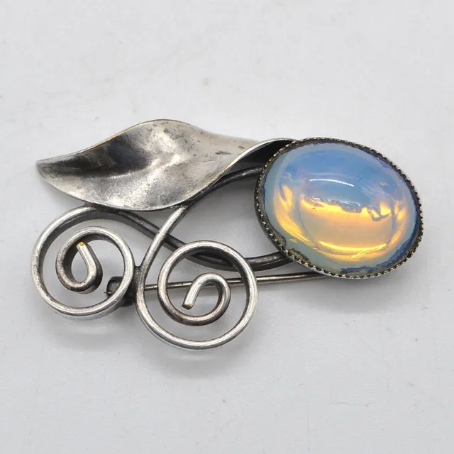 JUGENDSTILBROSCHE AUS SILBER (GEPRÜFT), OPALITH-CABOCHON, HANDGEMACHT, UM 1900.