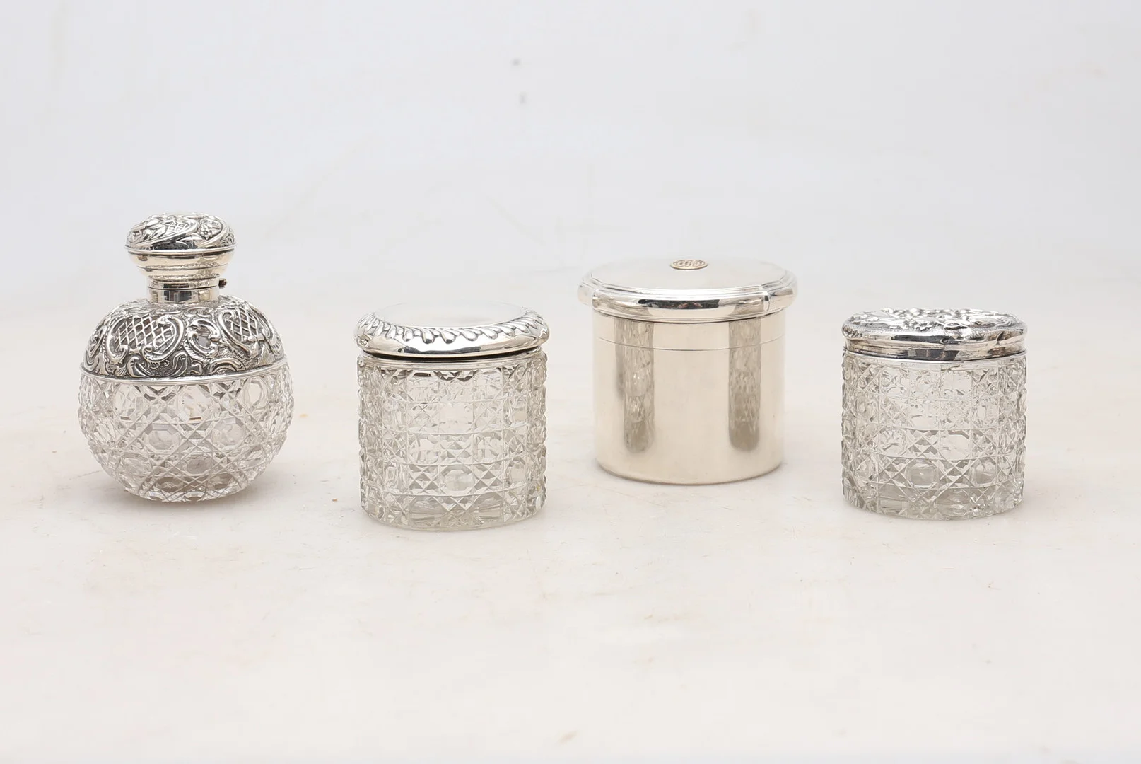 English lidded pot by Godsmiths & Silversmiths, from 1926, and three vanity jars in carved glass and silver. — Silver — Balclis