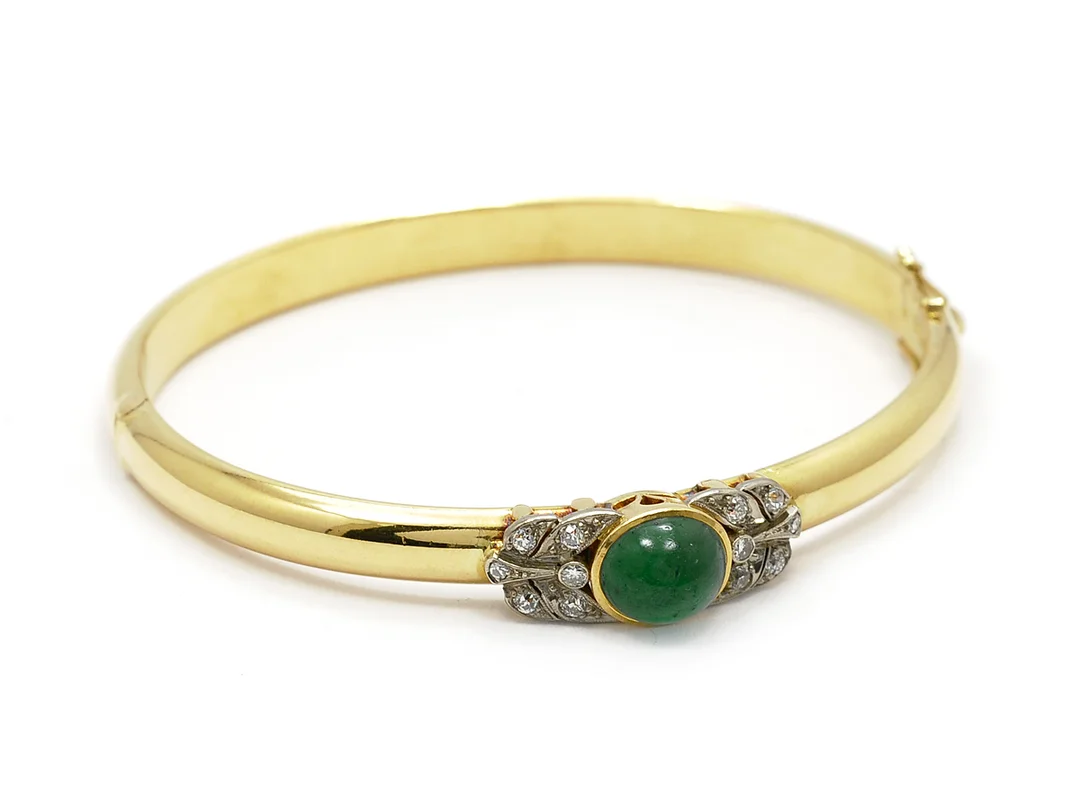 ARMRING, 18K guld, cabochonslipad smaragd, 12 diamanter ca 0,30ctv, ca W/VS-SI, 1 skadad, 5,2 x 6,2 cm, vikt 21,2 g, Stockholm 1955. — Smycken/Armring — Kaplans