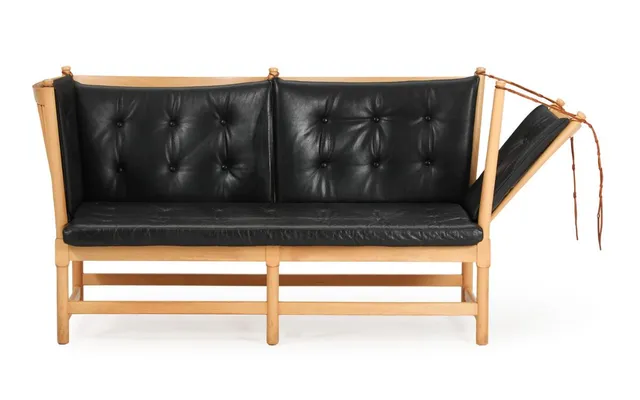 “The spoke-back sofa”. Two-seater sofa with beech frame, pull-out side and back with spokes, loose cushions in seat and back upholstered with black leather. Model 1789. Designed 1945. Manufactured by Fritz Hansen. L. 160 cm.