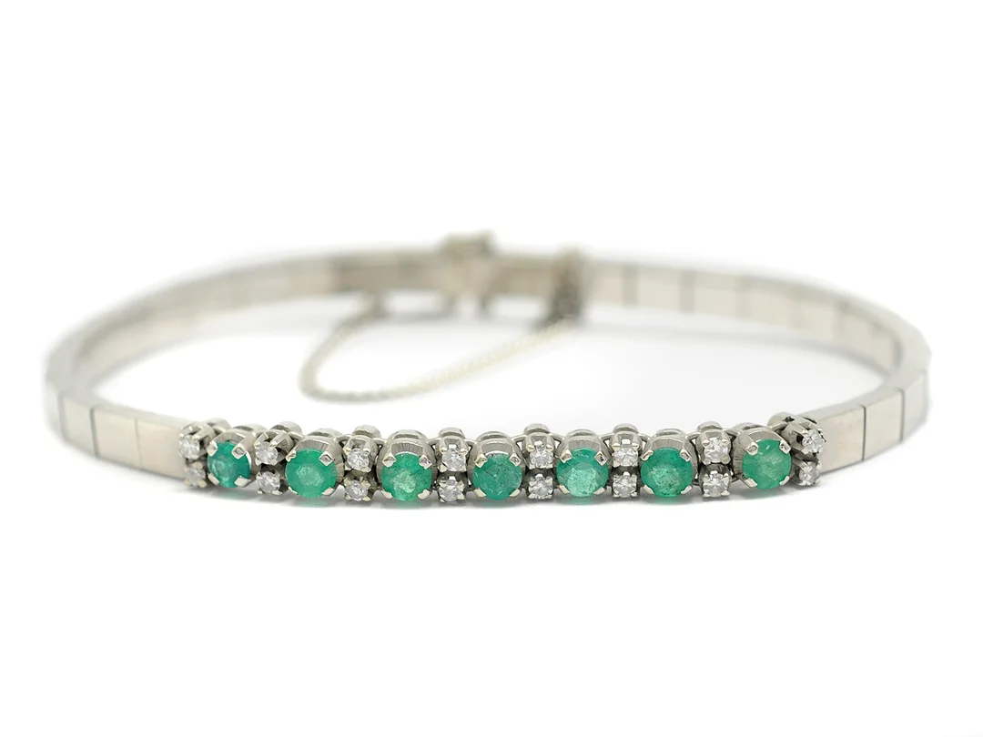 ARMBAND, 18K rodierat vitguld, smaragder, 16 åttkantslipade diamanter ca 0,37 ctv, ca W/VS, diameter ca 5,5 cm, säkerhetskedja, vikt 16,6 g. — Smycken/Armband — Kaplans