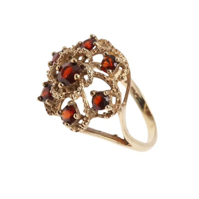 A GARNET AND 9CT YELLOW GOLD CLUSTER RING.