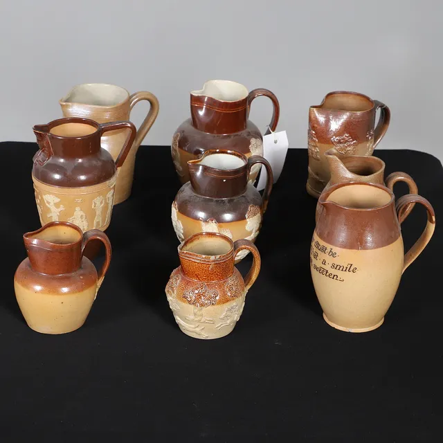 NINE DOULTON LAMBETH AND OTHER STONEWARE PITCHERS AND JUGS.