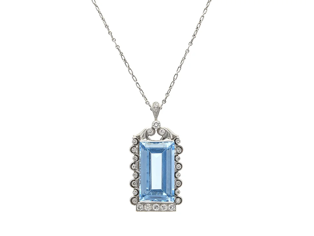 HÄNGE/KEDJA, platina, baguetteslipad syntetisk blå spinell ca 50,00 ct, 26 briljant- äldre briljant- och åttkantslipade diamanter ca 1,50 ctv, ca TW-TCa(G-K)/VS-P, Owen & Larsson, Stockholm 1949, hängets höjd 52 mm, längd 45/52 cm, vikt 34,3 g, skadat originaletui, några diamanter har nagg och naturaler. — Smycken/Hänge med kedja — Kaplans