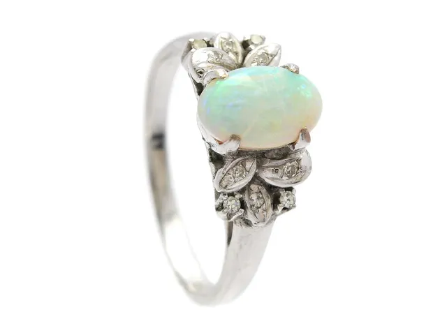 RING, 18K vitguld, opal, 10 åttkantslipade diamanter ca 0,05 ctv, stl 18 mm, vikt 3,7 g, opalen har en spricka.