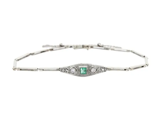 ARMBAND, 18K vitguld / platina, smaragd, 2 briljantslipade och 2 fasetterade diamanter ca 0,12 ct, längd 16 cm, vikt 5,1 g, skada på en av de mindre diamanterna.