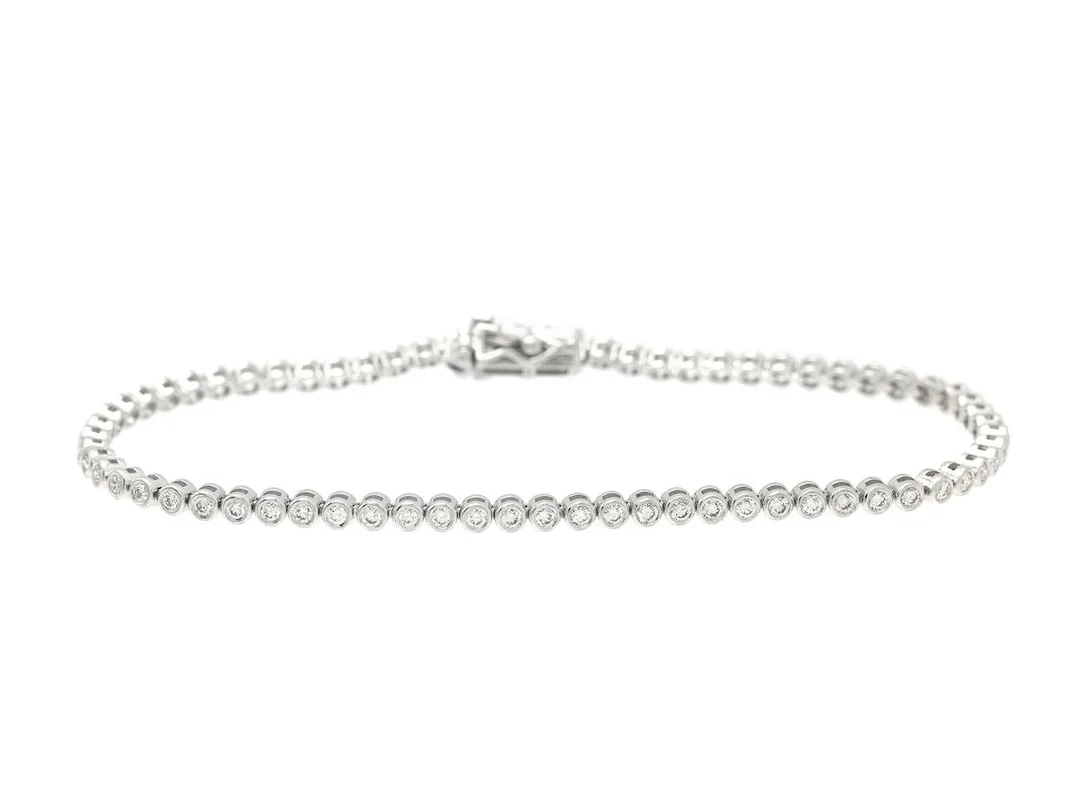 TENNISARMBAND, 18K vitguld, 69 briljantslipade diamanter ca 1,18 ctv, ca TW-TCa/VVS-VS, längd 17,5 cm, vikt 7,0 g, enstaka diamanter med nagg på kuletten. — Smycken/Tennisarmband — Kaplans