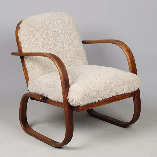 DANSK DESIGN. Lænestol af formbøjet bøg, nypolstret med lammeskind, model 1, Fritz Hansen, Danmark, 1940'erne.