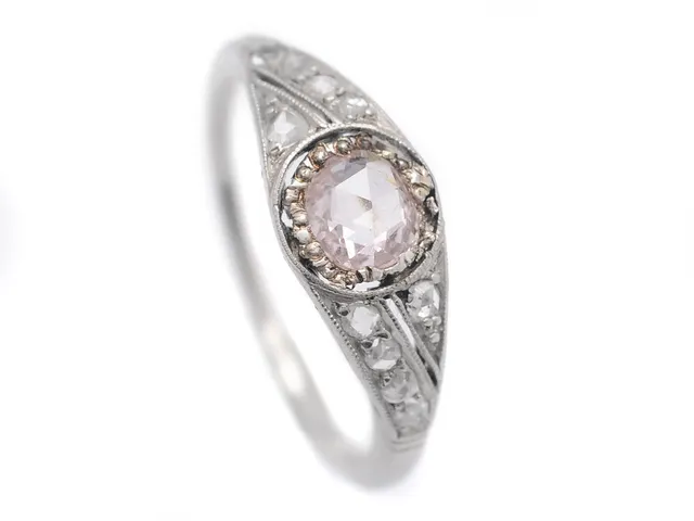 RING, platina, svagt rosa rosenslipad diamant, 10 mindre rosenslipade diamanter, stl 17,25 mm, vikt 2,6 g, skadad ringskena.