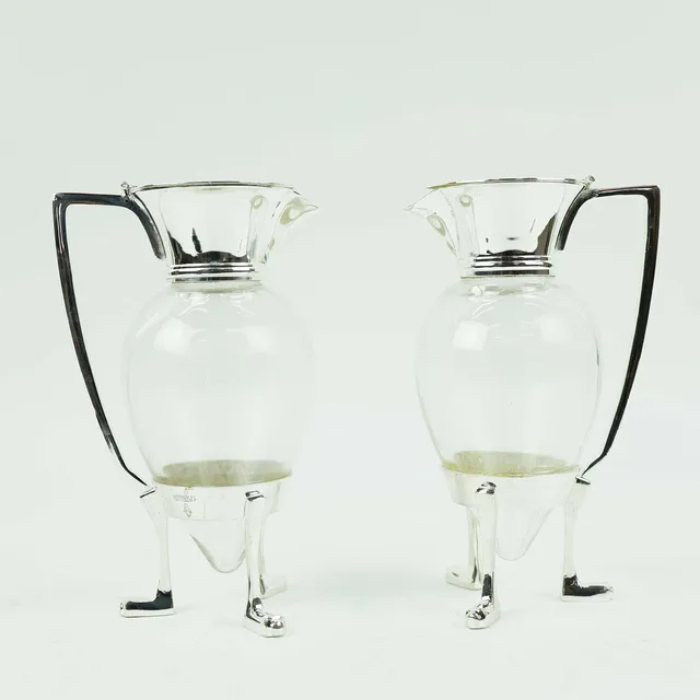 A PAIR OF CHRISTOPHER DRESSER STYLE CLARET JUGS.