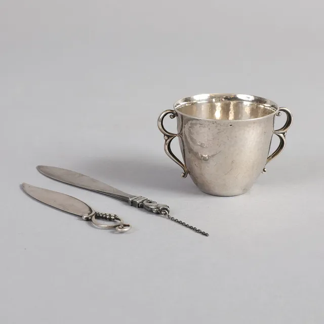 GEORG JENSEN. En børnekop samt to brevknive af sterlingsølv, art deco, 1930-1940'erne (3).