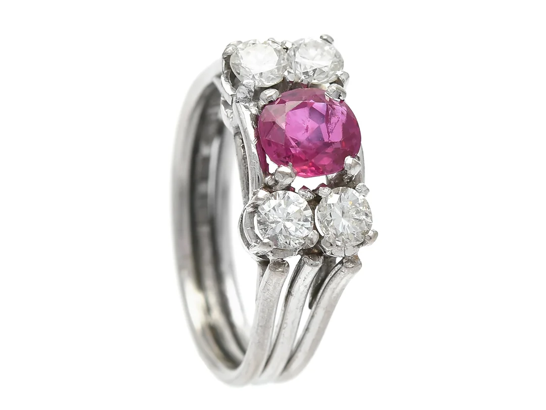 RING, 18K vitguld, ovalslipad rubin ca 0,80 ct, 4 briljantslipade diamanter ca 0,50 ctv, ca W-Cr(H-J)/SI, Sigu Atelje, Stockholm 1959, stl 15,75 mm, vikt 4,6 g, rubinen med slitna fasettkanter, inneslutning och litet nagg på rondisten. — Smycken/Ring — Kaplans