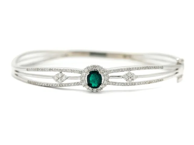 ARMRING, 18K rodierat guld, smaragd 0,35 ctv, briljantslipade diamanter ca 0,75 ctv, ca W(H)/SI-P, 6 x 5 cm, vikt 15,4 g, en mindre diamant skadad.