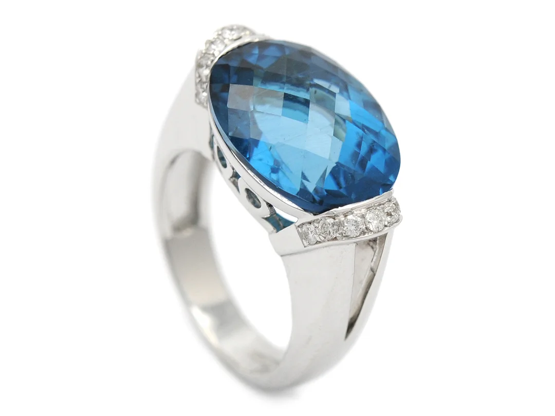 RING, 18K vitguld, ovalslipad fasetterad topas ca 8,50 ct, 14 briljantslipade diamanter, ca 0,27 ctv, ca TW/VS, stl 16,5 mm, vikt 11,7 g. — Smycken/Ring — Kaplans