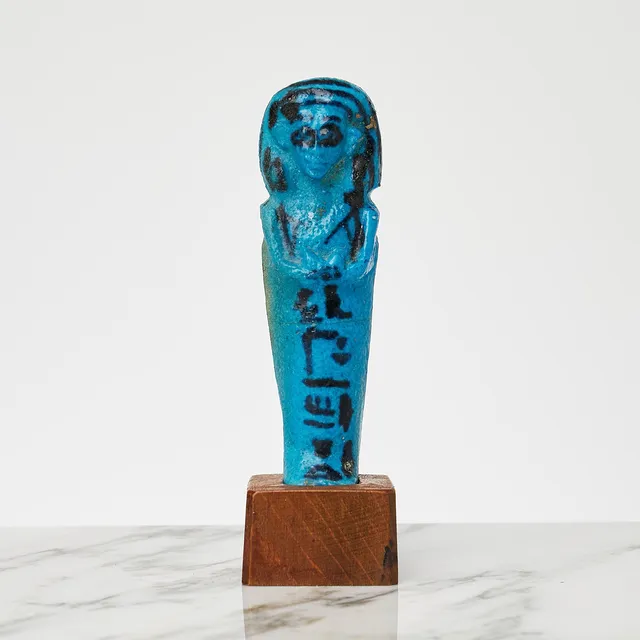 USHABTI för Amenope, präst i Thebe, tredje mellanperioden, 21 dynastin, ca 1069-943 f Kr, blåglaserad fajans, med sockel i trä.