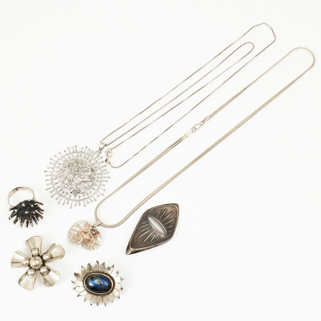 HALSKEDJOR MED HÄNGEN, 2 st., varav en Theresia Hvorslev, MEMA, Lidköping, RING, BROSCHER, 3 st., silver/sterlingsilver, delvis brutalistisk stil, en blomformad brosch stämplad Sven-Erik Högberg, Helsingborg 1967. — Necklace — Stockholms Auktionsverk Magasin 5