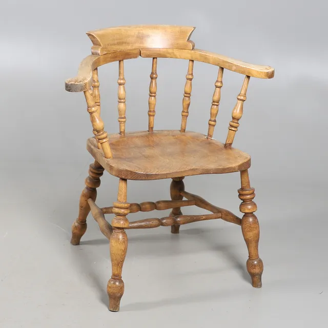 A REPRODUCTION VICTORIAN STYLE BEECH AND ELM SMOKERS BOW ELBOW CHAIR.