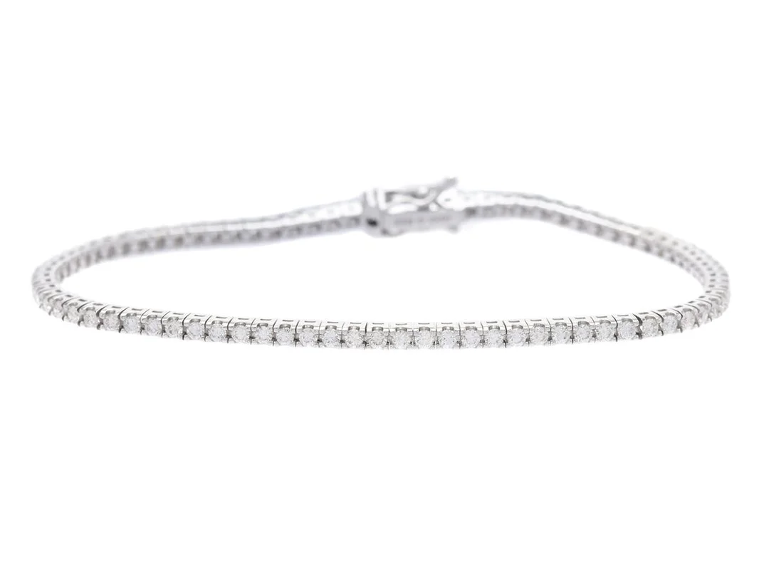 TENNISARMBAND, 18K vitguld, 82 briljantslipade diamanter ca 1,69 ctv, ca TW-TCr/VVS-VS, längd 17,5 cm, vikt 7,7 g. — Smycken/Tennisarmband — Kaplans