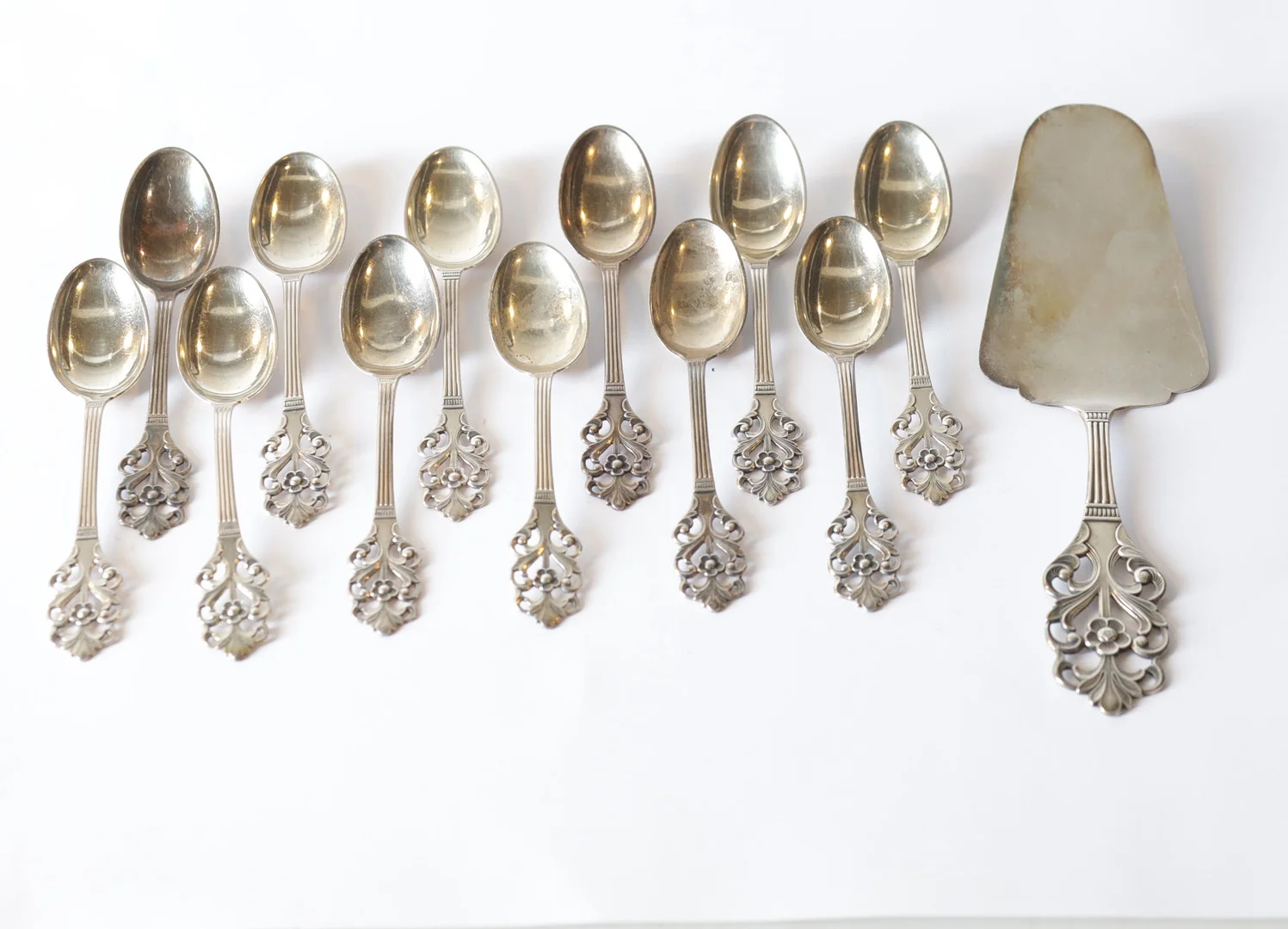 THORVALD MARTHINSEN. Kaffeskedar samt tårtspade, 13 st delar, blomdekor kattfot, Totalvikt ca 160g. 830 silver. — Silver — Gomér & Andersson Nyköping