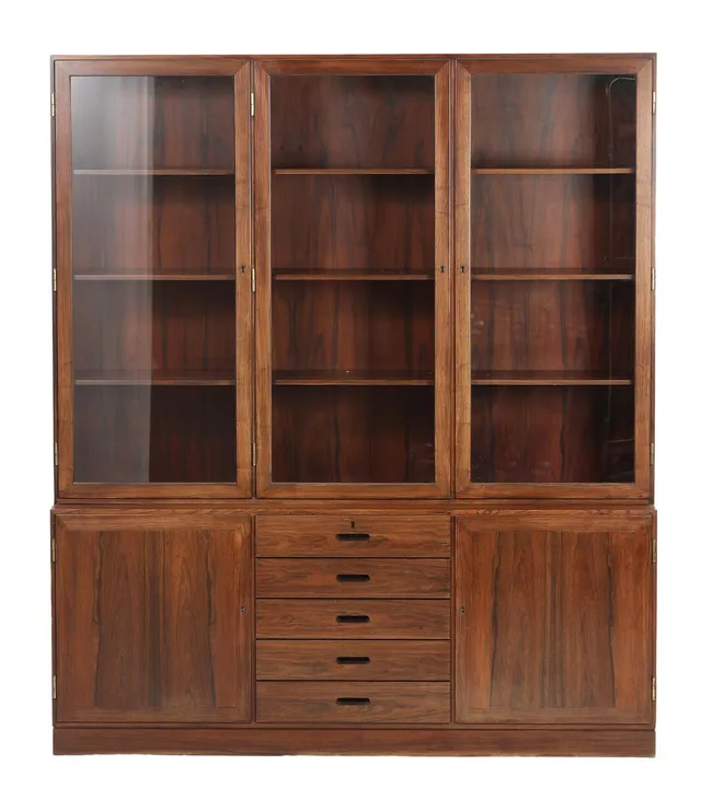 Rosewood display cabinet, lower section with two doors and five drawers and upper section with three doors, behind which shelves. Manufactured by P. Jeppesen. 1960s. Lower section including plinth H. 68. W. 164. D. 40. Upper section H. 123. W. 164. D. 30 cm.