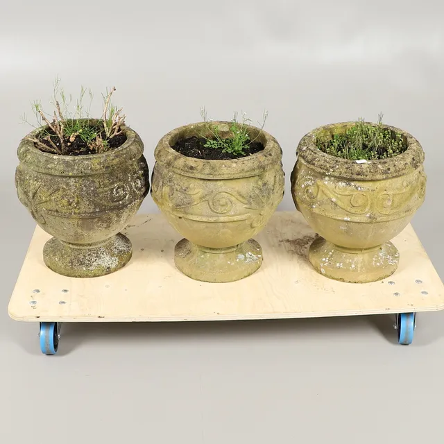 A TRIO OF RECONSTITUTED STONE URN PLANTERS.