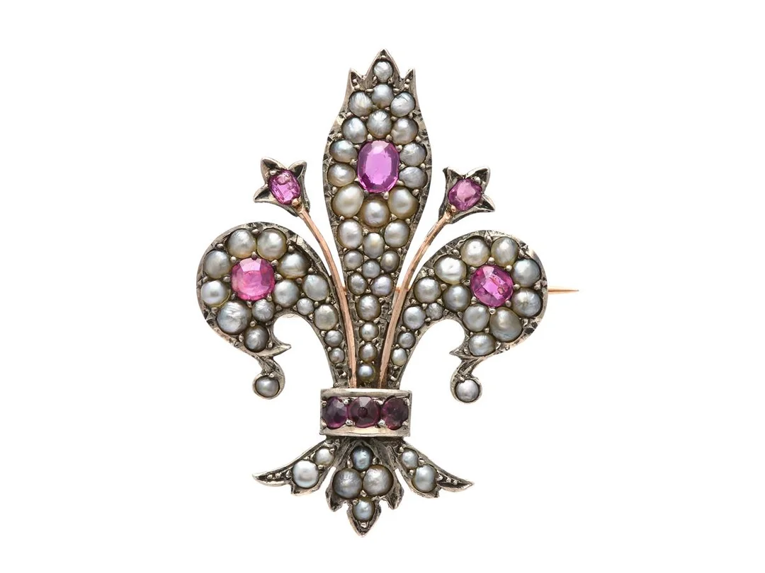 BROSCH, Fransk lilja, silver/14K guld, rubiner, orientaliska halvpärlor, 28x38 mm, vikt 7,4 g, en rubin med inneslutning som når ytan, några odlade pärlor. — Smycken/Brosch — Kaplans