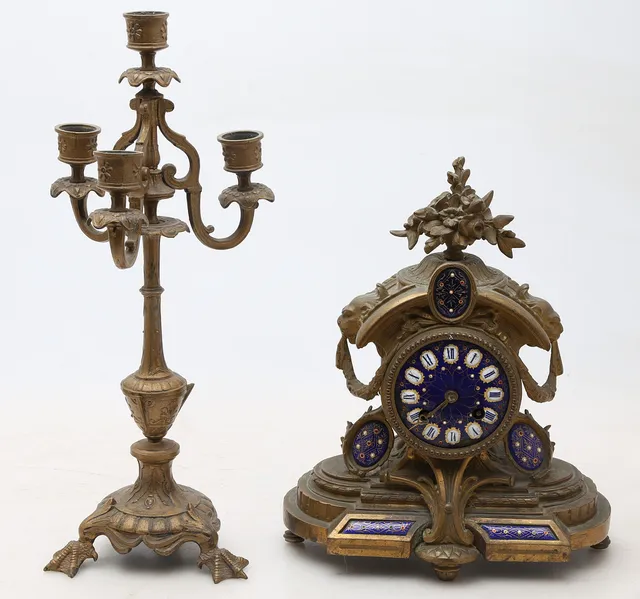 Reloj de estilo Luis XVI en bronce dorado con decoración esmaltada en azul y candelabro, de las primeras décadas del siglo XX.