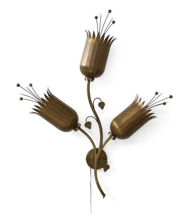 A brass wall lamp with three burners and shades shaped as flowers. L. 80 cm.