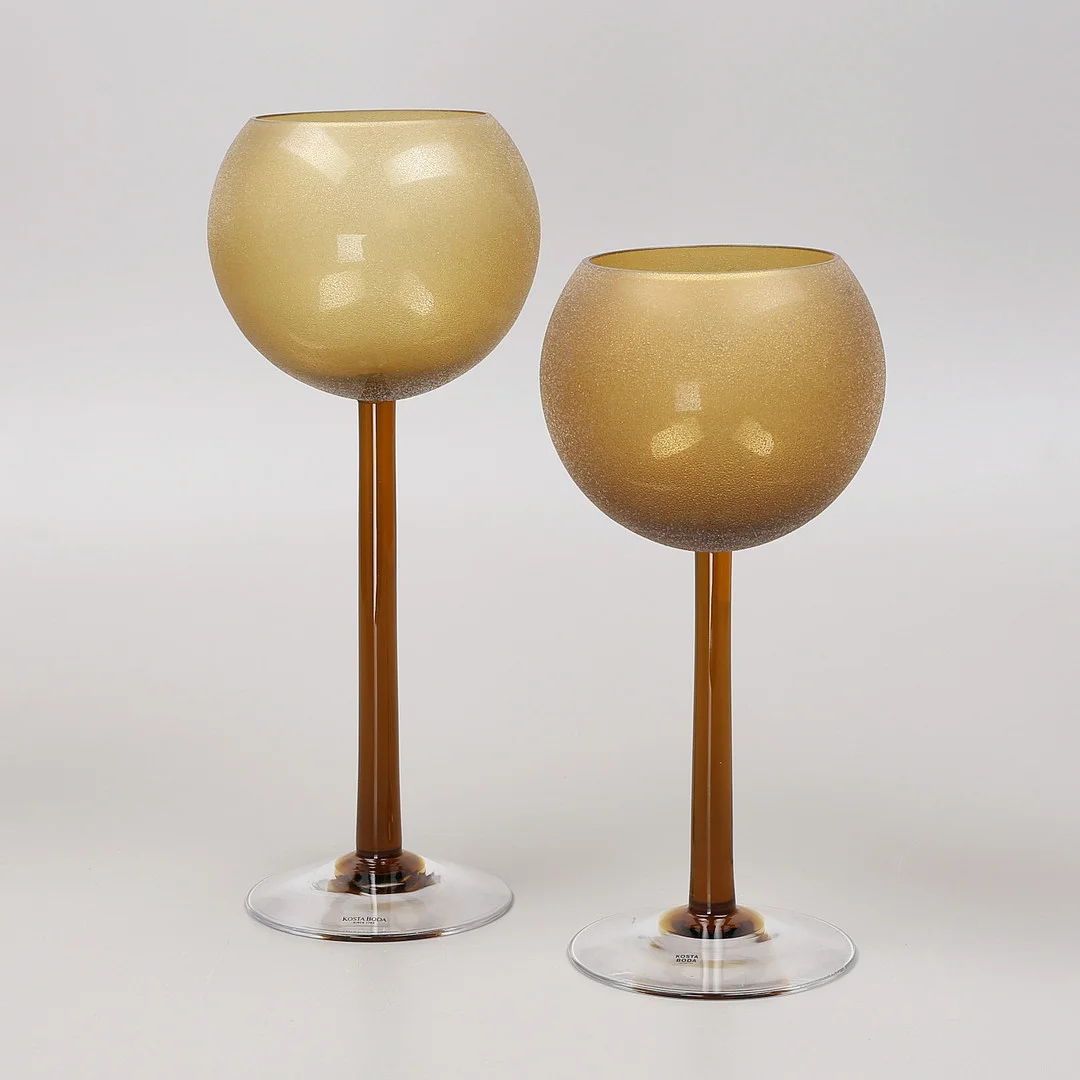 ANNE NILSSON. Ljuslyktor på fot, 2 st, "Hurricane", Kosta Boda, signerad. — Utility glass — Växjö Auktionskammare