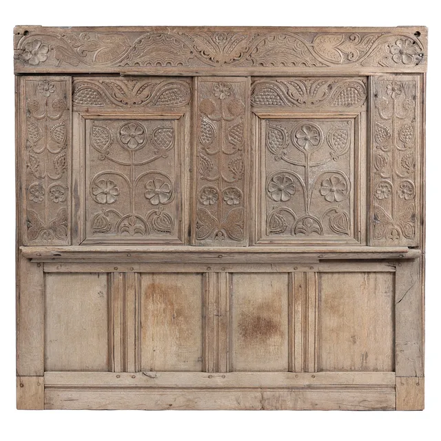 A CARVED OAK HEADBOARD.