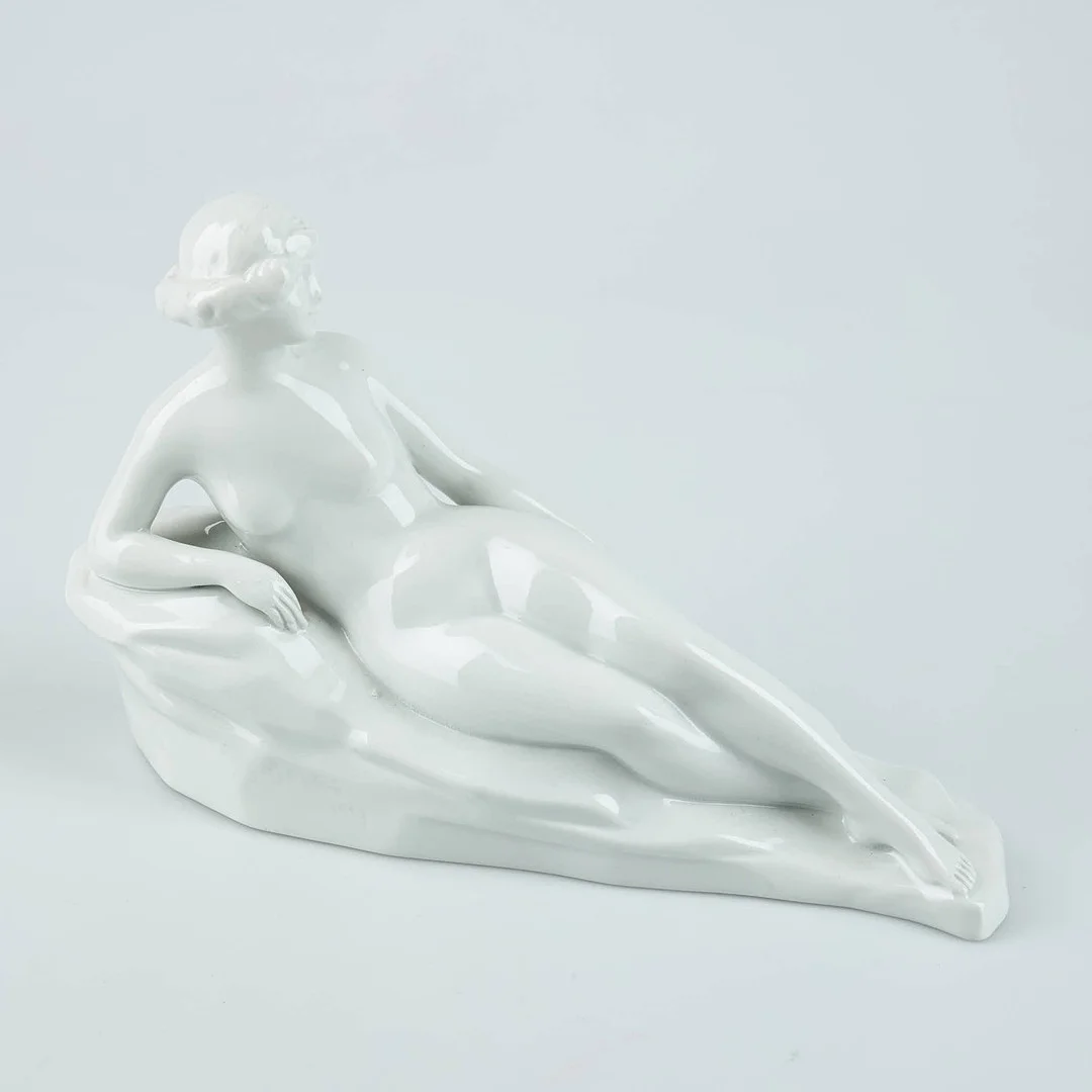 FIGURIN, liggande dam, porslin, Gustaf (Gunnar) Nyholm, signerad samt daterad 1927, Arabia. — European — Stockholms Auktionsverk Helsinki