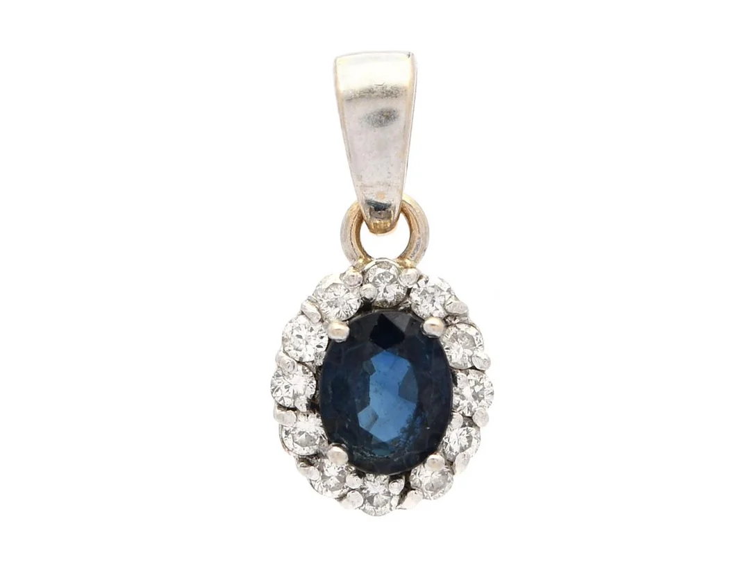 CARMOSÉHÄNGE, 18K vitguld, ovalslipad blå safir 0,41 ct, briljantslipade diamanter 0,12 ctv, ca TW/VS, mått 0,6 x 1,3 cm, vikt 0,7 g, några diamanter ligger snett i sin fattning, safiren har nagg på fasettkanter. — Smycken/Hänge — Kaplans