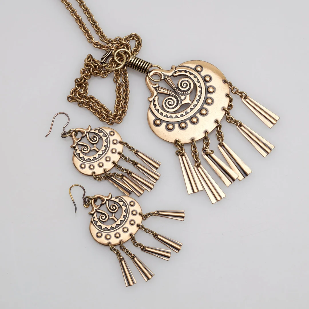 KALEVALA KORU. "Mångudinnan", örhängen, halsband, 3 delar, brons, Finland. — Jewellery Suites — Växjö Auktionskammare
