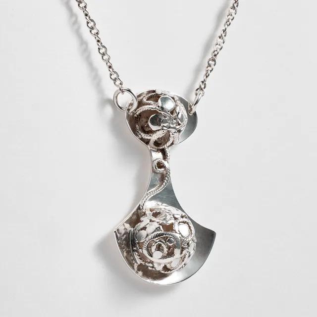 ROSA TAIKON. collier, silver, Ytterhogdal 1987, hänge i form av en yxa efter Taikons fars romska signum, dekor av tvinnad tråd.