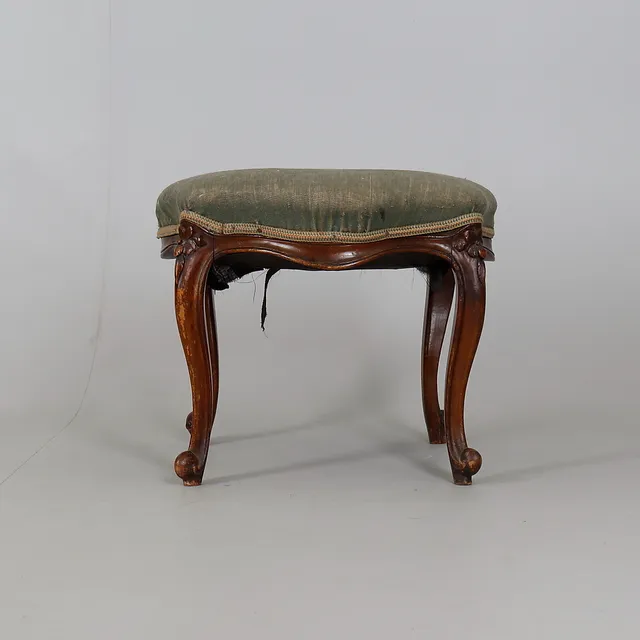 A CARVED MAHOGANY AND UPHOLSTERED STOOL IN 18TH CENTURY TASTE.