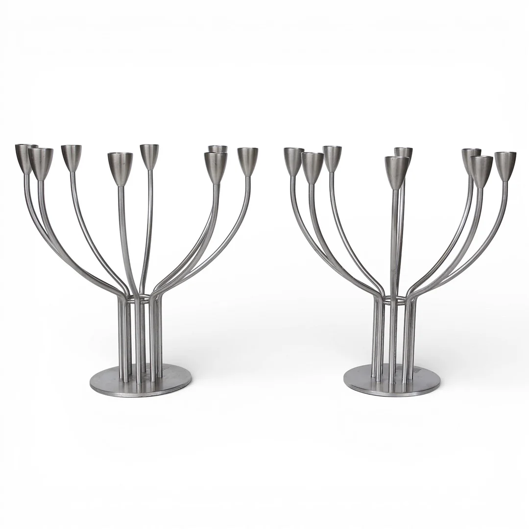 KNUT OCH MARIANNE HAGBERG. Kandelabrar rostfritt stål, ur kollektionen "IKEA Stockholm" år 1999, 8 kronljus vardera. — Candlesticks — Limhamns Auktionsbyrå