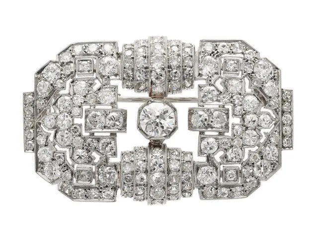 BROSCH, platina, gammalslipad diamant ca 0,82 ct, TCr(I)/P, 186 gammal- och åttkantslipade diamanter ca 5,00 ctv, ca TW-TCr/VS-P, mått 46x29 mm, vikt 18,3 g, några svaga fattningar, mittstenen har små skador och nagg vid rondisten i anslutning till inneslutning som når ytan, flera sidostenar har nagg och skador.