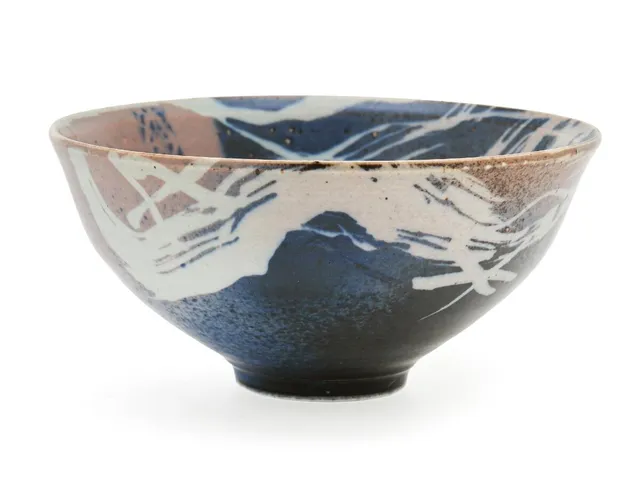 A circular stoneware bowl decorated with grey, brown-rose and blue glaze. Signed monogram. Royal Copenhagen. Unique. H. 10.5 cm. Diam. 22.5 cm.