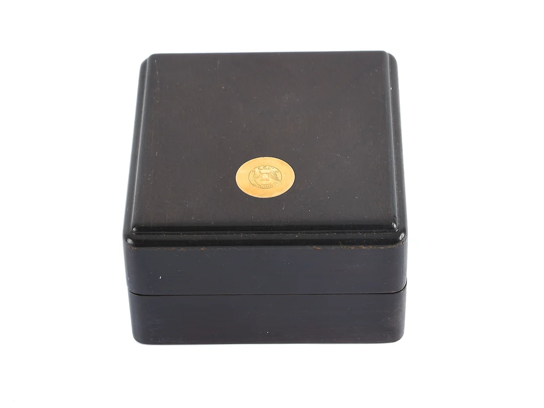 TRÄBOX, till Longines herrur, brun, 113 x 120 x 64 mm, skadad, ca 1995. — Klocktillbehör/Longines — Kaplans
