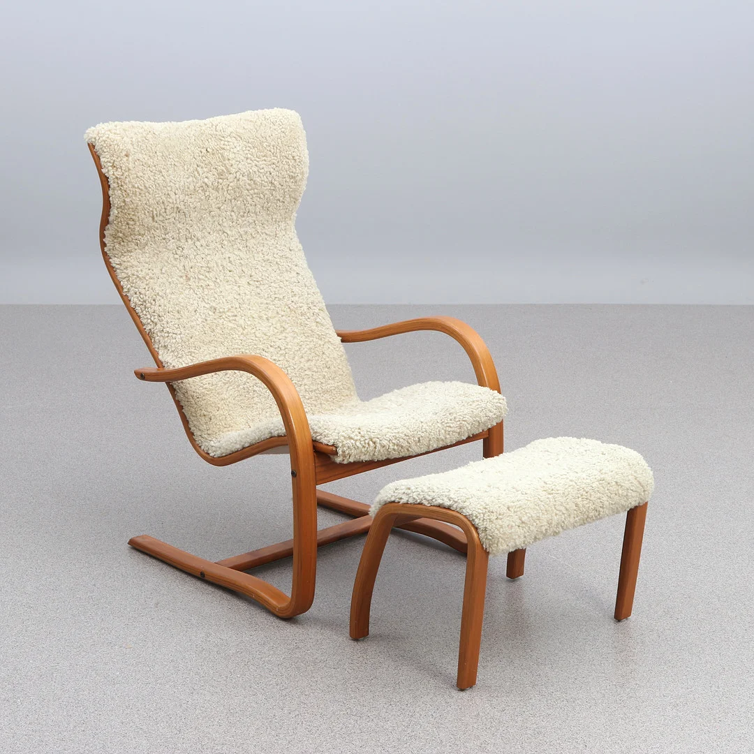 JAN EKSTRÖM. FÅTÖLJ MED FOTPALL. Teak med fårskinnsklädsel. "Gazell", Conform, samtida tillverkning. — Armchairs & Chairs — Skånes Auktionsverk