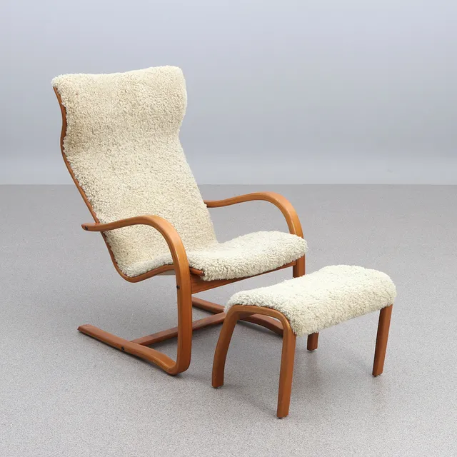 JAN EKSTRÖM. FÅTÖLJ MED FOTPALL. Teak med fårskinnsklädsel. "Gazell", Conform, samtida tillverkning.