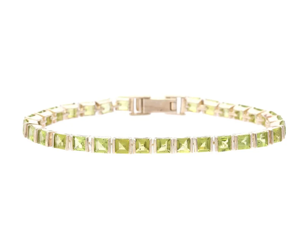 ARMBAND, sterlingsilver, peridoter, längd 17,5 cm, vikt 14,0 g, en peridot skadad och några med slitna fasettkanter. — Smycken/Armband — Kaplans