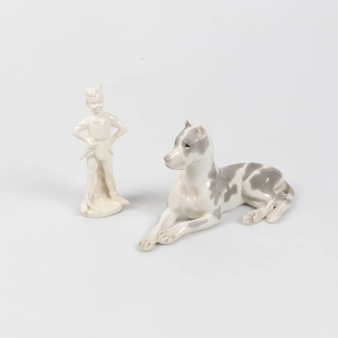 FIGURINER, 2 stycken, hund samt Peter Pan, Lomonosov USSR och Goebel, porslin, 1900-talets andra hälft. — European — Stockholms Auktionsverk Helsingborg