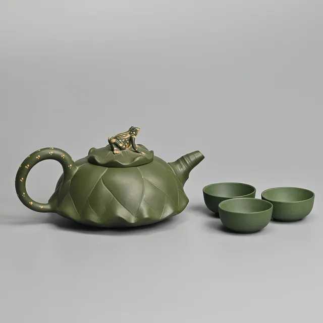 A CHINESE YIXING GREEN POTTERY TEA POT AND THREE CUPS, 20TH CENTURY.