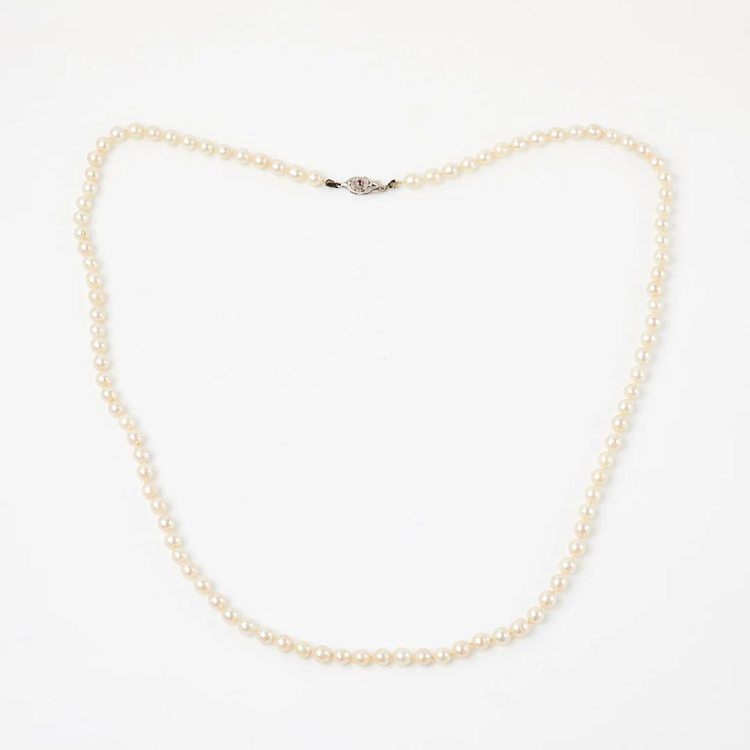PÄRLCOLLIER, odlade vita saltvattenspärlor, ca 5,9-6,4 mm, lås av silver, dekor av 1 fasettslipad rubin. — Necklace — Stockholms Auktionsverk Sickla